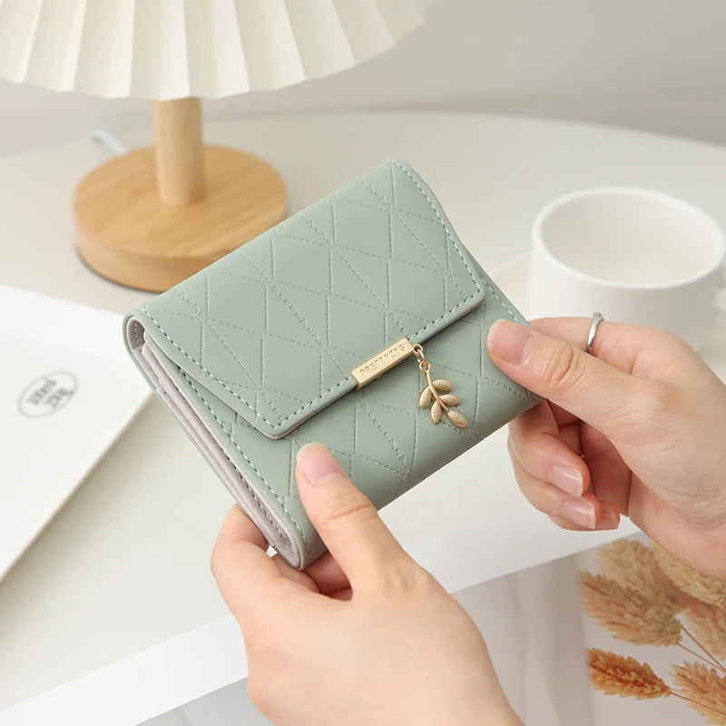 Cartera corta para mujer, nueva, de otoño e invierno, fabricada en Japón y Corea del Sur, pequeña, fresca, de PU, plegable, con colgante de hoja y tres pliegues.