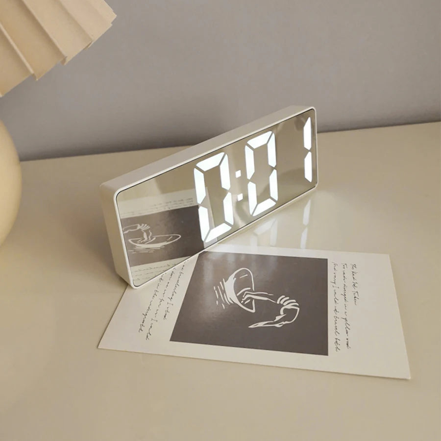 Reloj despertador moderno minimalista con control por voz, multifuncional y portátil con pantalla LED y superficie de espejo en blanco y negro.