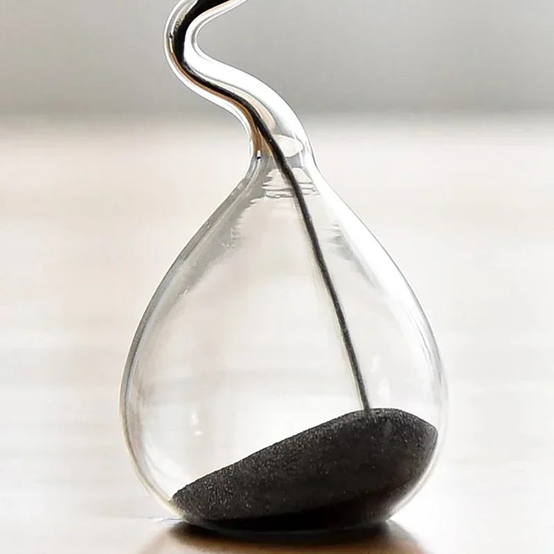 Decoración minimalista para mesa de comedor con diseño curvo de estilo moderno en color negro y artesanía en forma de reloj de arena.