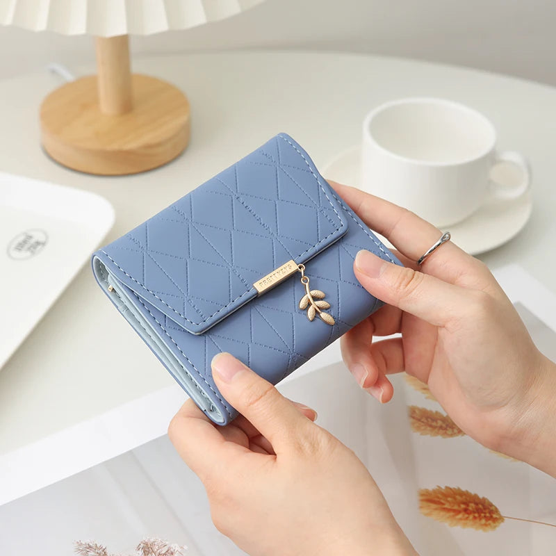 Cartera corta para mujer, nueva, de otoño e invierno, fabricada en Japón y Corea del Sur, pequeña, fresca, de PU, plegable, con colgante de hoja y tres pliegues.