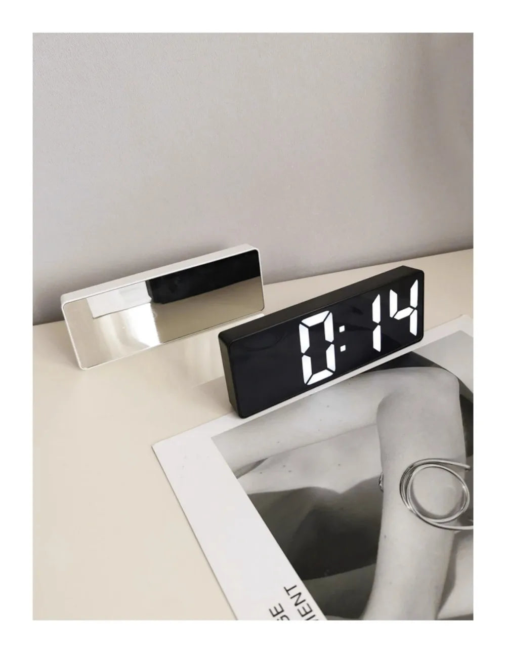 Reloj despertador moderno minimalista con control por voz, multifuncional y portátil con pantalla LED y superficie de espejo en blanco y negro.