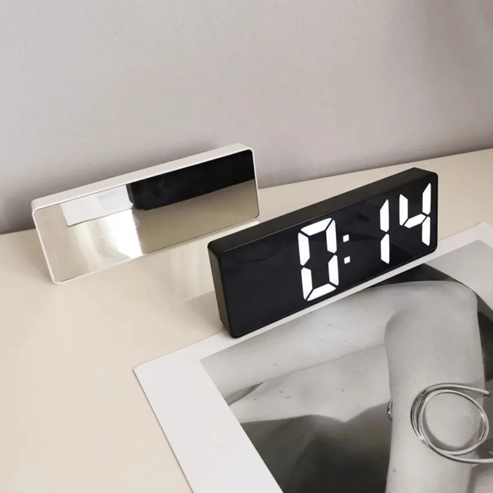 Reloj despertador moderno minimalista con control por voz, multifuncional y portátil con pantalla LED y superficie de espejo en blanco y negro.