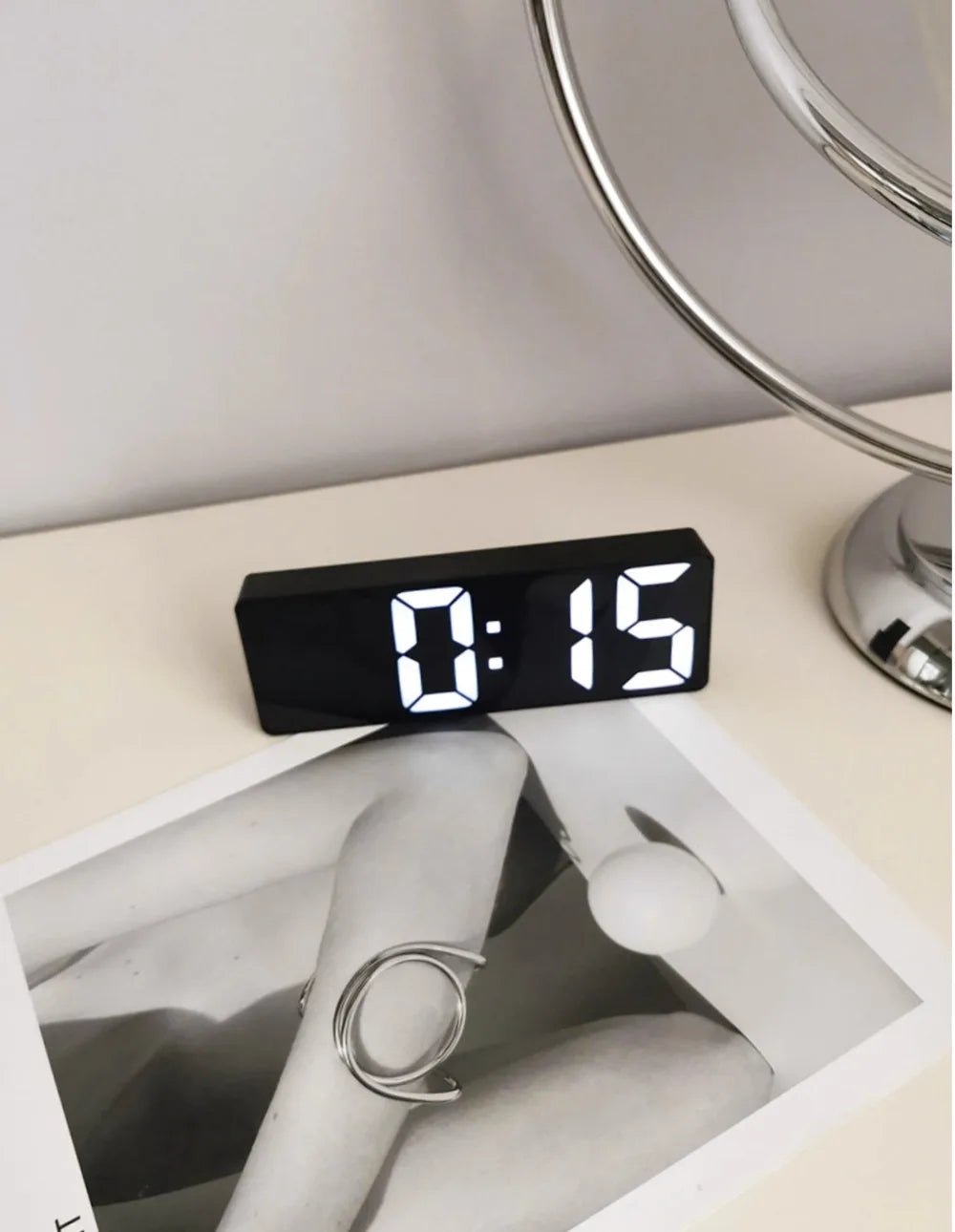 Reloj despertador moderno minimalista con control por voz, multifuncional y portátil con pantalla LED y superficie de espejo en blanco y negro.