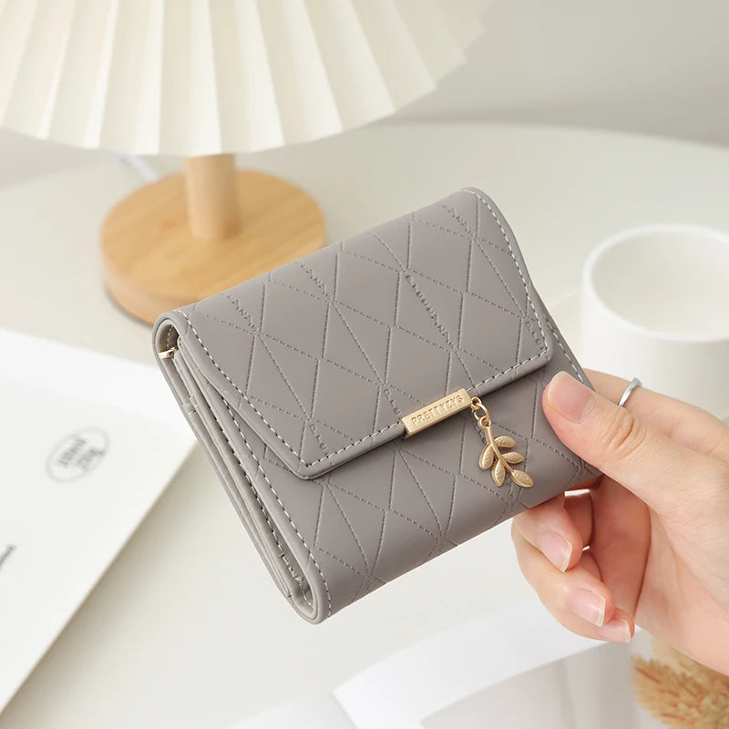 Cartera corta para mujer, nueva, de otoño e invierno, fabricada en Japón y Corea del Sur, pequeña, fresca, de PU, plegable, con colgante de hoja y tres pliegues.
