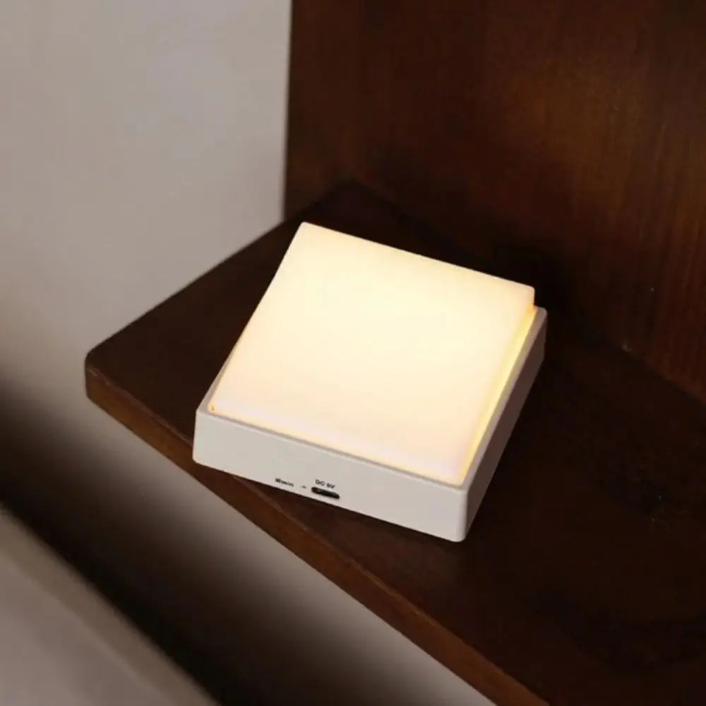 Luz nocturna LED con atenuación continua, protección ocular, succión magnética, diseño blanco y amarillo, carga USB.