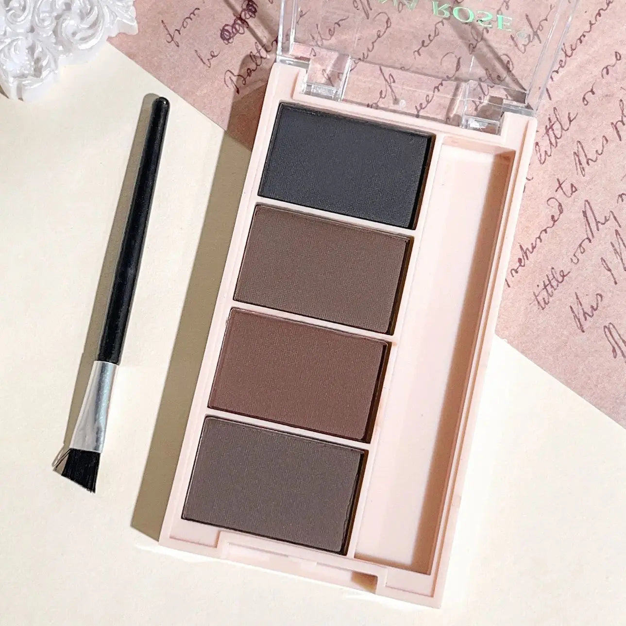 Un juego de bandejas de polvo para cejas de 4 colores con pinceles en tonos gris y marrón mate para una reproducción de color duradera, relleno y definición.