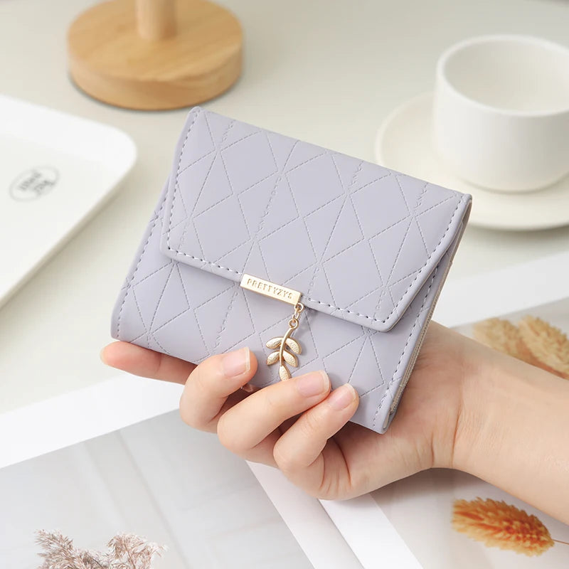 Cartera corta para mujer, nueva, de otoño e invierno, fabricada en Japón y Corea del Sur, pequeña, fresca, de PU, plegable, con colgante de hoja y tres pliegues.