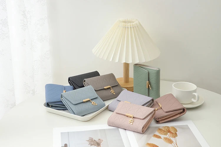 Cartera corta para mujer, nueva, de otoño e invierno, fabricada en Japón y Corea del Sur, pequeña, fresca, de PU, plegable, con colgante de hoja y tres pliegues.