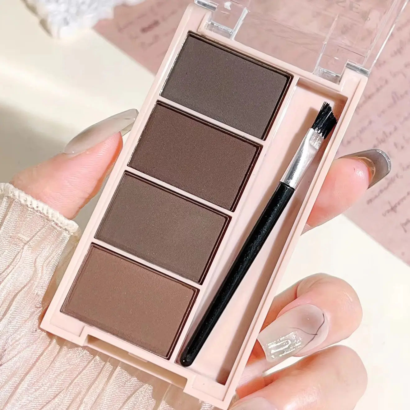 Un juego de bandejas de polvo para cejas de 4 colores con pinceles en tonos gris y marrón mate para una reproducción de color duradera, relleno y definición.