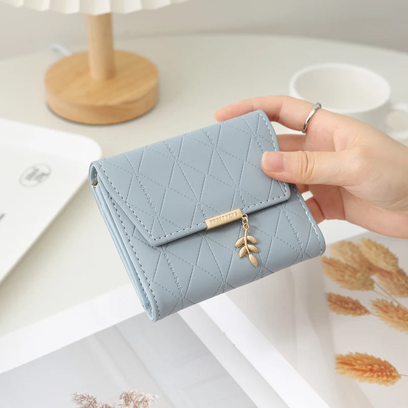 Cartera corta para mujer, nueva, de otoño e invierno, fabricada en Japón y Corea del Sur, pequeña, fresca, de PU, plegable, con colgante de hoja y tres pliegues.
