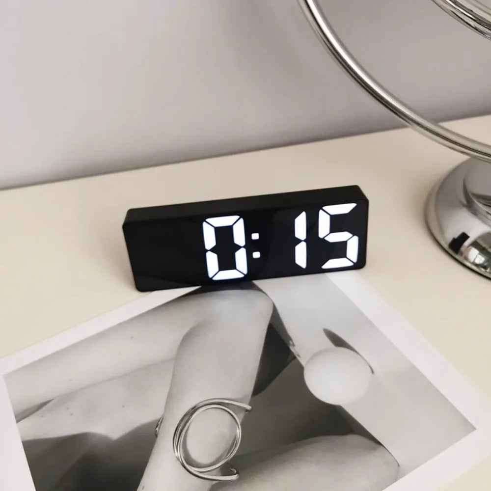 Reloj despertador moderno minimalista con control por voz, multifuncional y portátil con pantalla LED y superficie de espejo en blanco y negro.