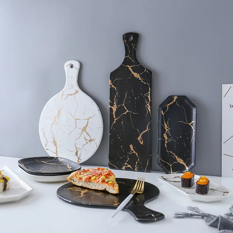 Vajilla de cerámica blanca, negra y dorada, ideal para pizza, postres, filetes y como bandeja decorativa.
