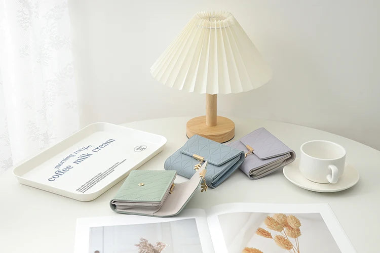 Cartera corta para mujer, nueva, de otoño e invierno, fabricada en Japón y Corea del Sur, pequeña, fresca, de PU, plegable, con colgante de hoja y tres pliegues.